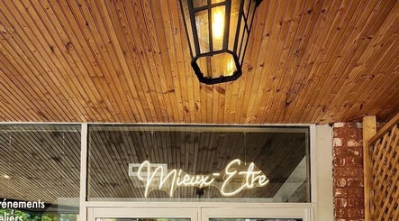 Elegant neon sign at Maison Rustik, Sainte-Thérèse, Québec, CA. Warm wooden ceiling and ambient lighting.