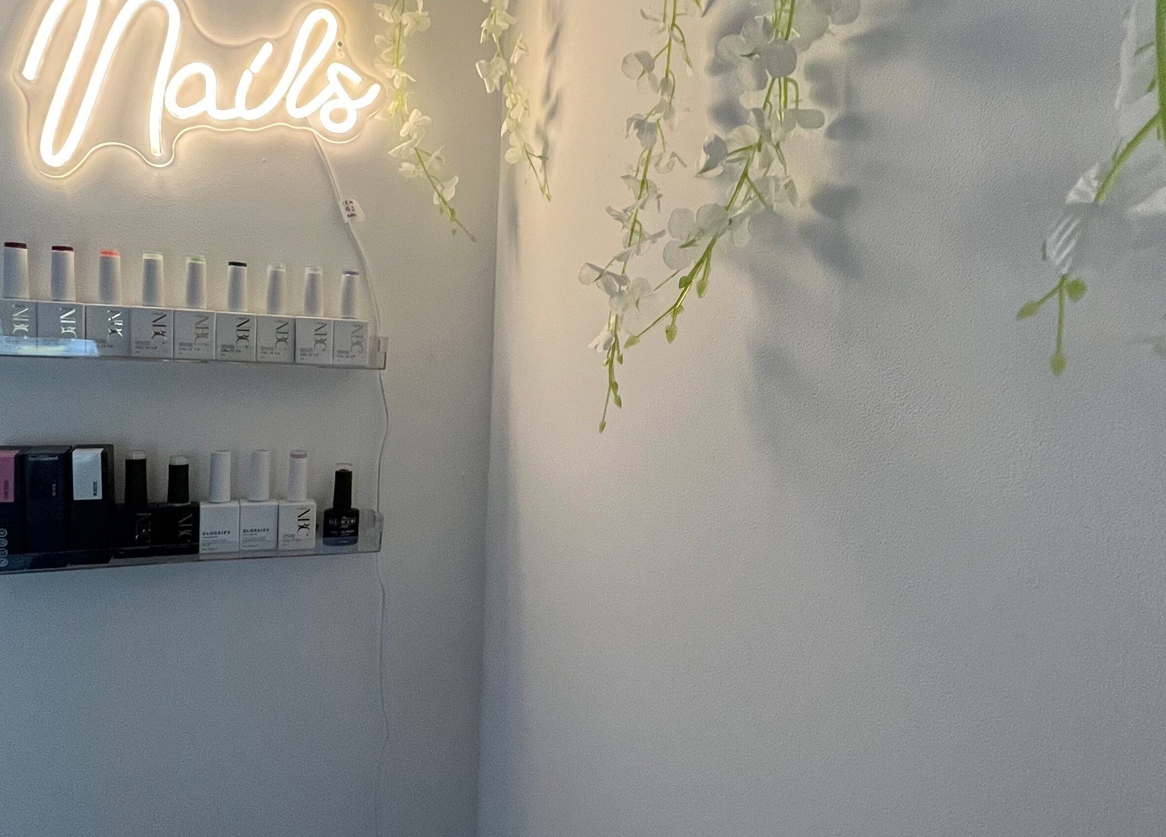 Nail polish display under neon sign at Nails by Lily, Horley, England, GB.