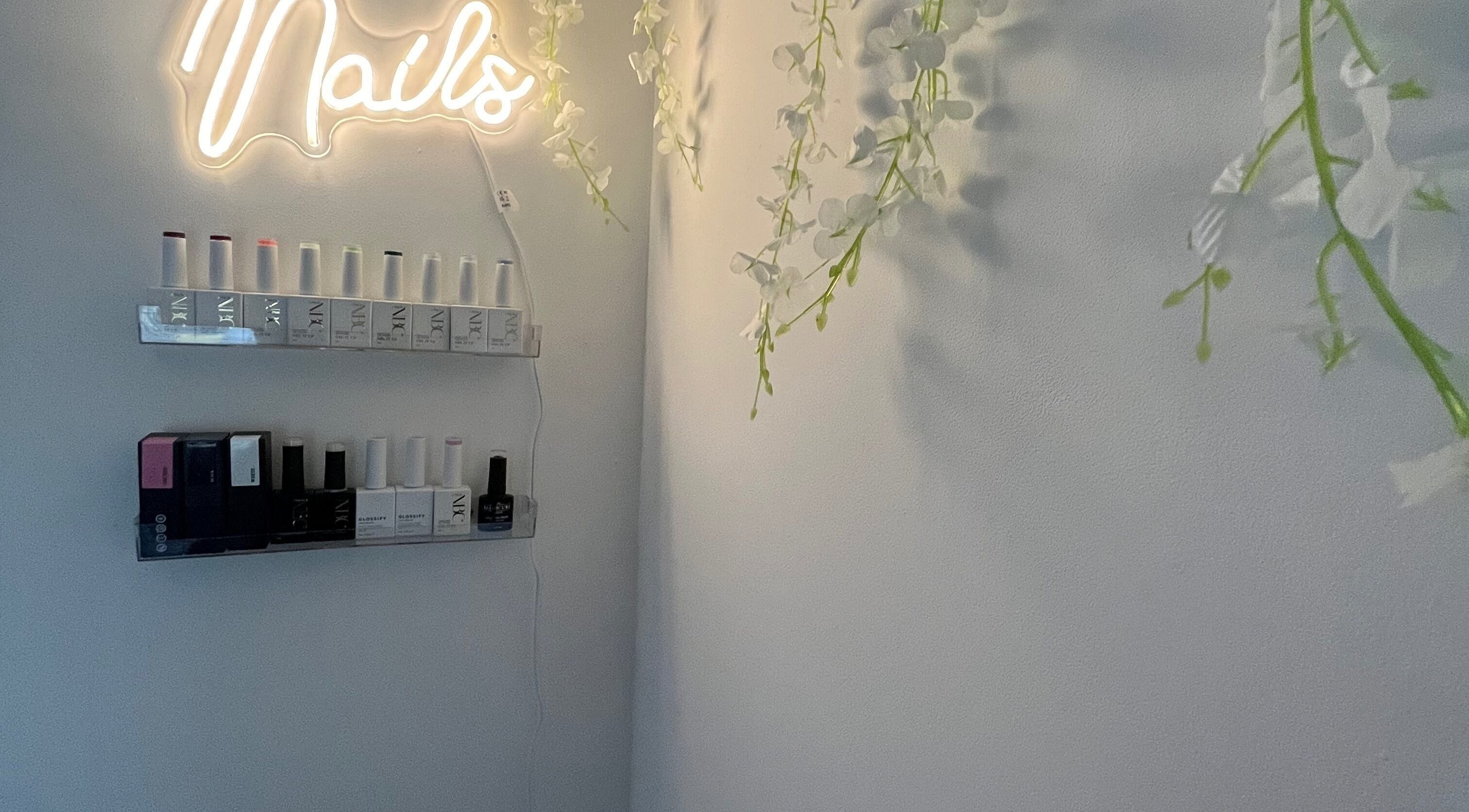 Nail polish display under neon sign at Nails by Lily, Horley, England, GB.