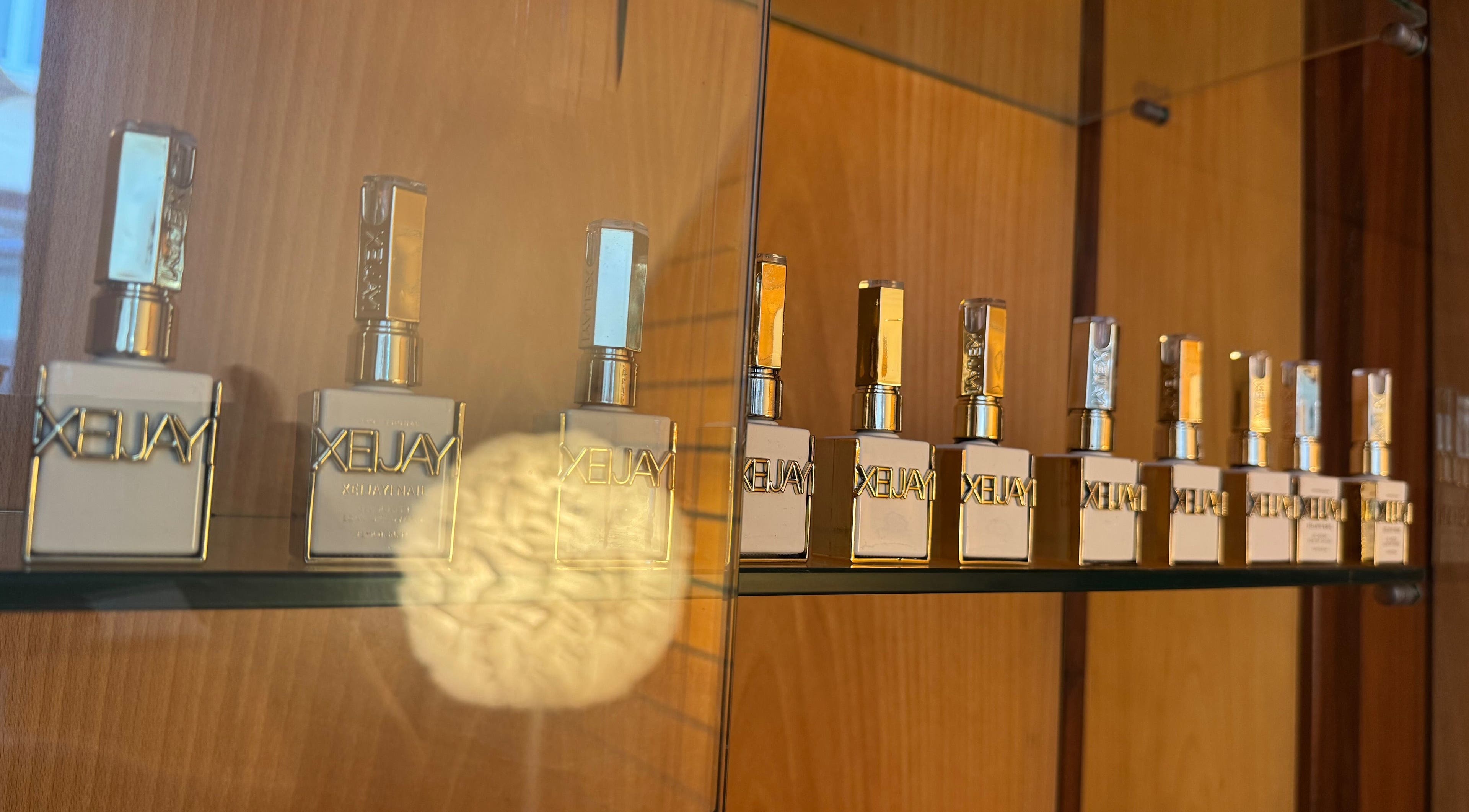 Frascos de perfume alinhados em prateleira no Karen Passos, Algés, Lisboa, PT.