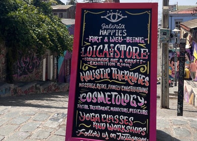 Cartel de terapias holísticas en Cosmefert, Valparaíso, Valparaíso, CL. Coloridos grafitis de fondo.