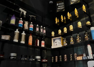 Product display at Mister Barber, Tétouan, showcasing premium hair and skincare products on sleek black shelves.