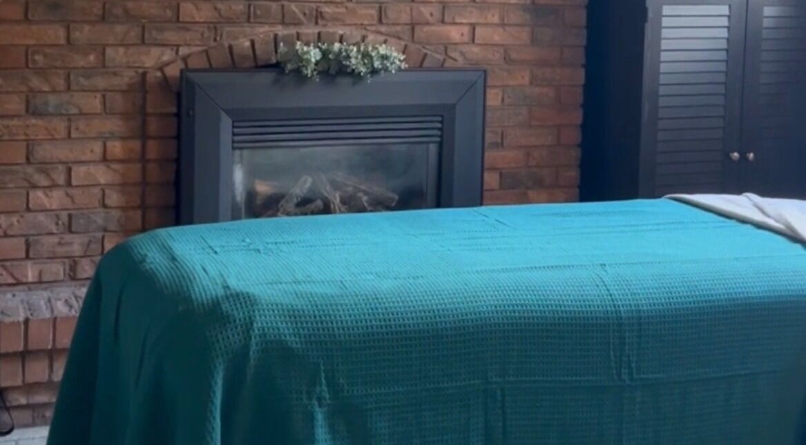 Massage table in front of a brick fireplace at Krista Shepley RMT, Alvinston, Ontario, CA for a serene treatment.