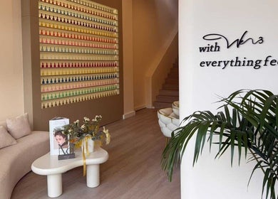 Modern interior of We3 Nails, Hawthorn, Victoria, AU, featuring a stylish waiting area and colorful nail polish display.