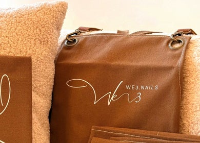 We3 Nails branded brown bag on beige cushion at Hawthorn, Victoria, AU beauty and wellness venue.