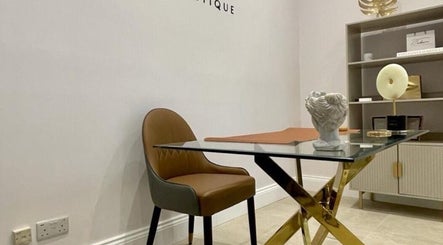Elegant workspace at Finesse Face™️, Molesey, England, GB, showcasing a chic chair and decorative art pieces.