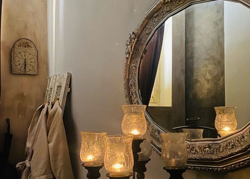 Καθρέφτης με κεριά στο Niriides Spa, Αθήνα, GR δημιουργεί ατμόσφαιρα χαλάρωσης.