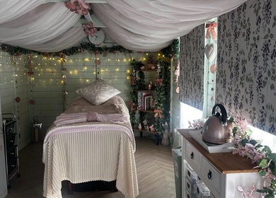 Calming massage room at Serenity View Massage & Beauty, Ashbourne, England, GB with soft lighting and floral decor.