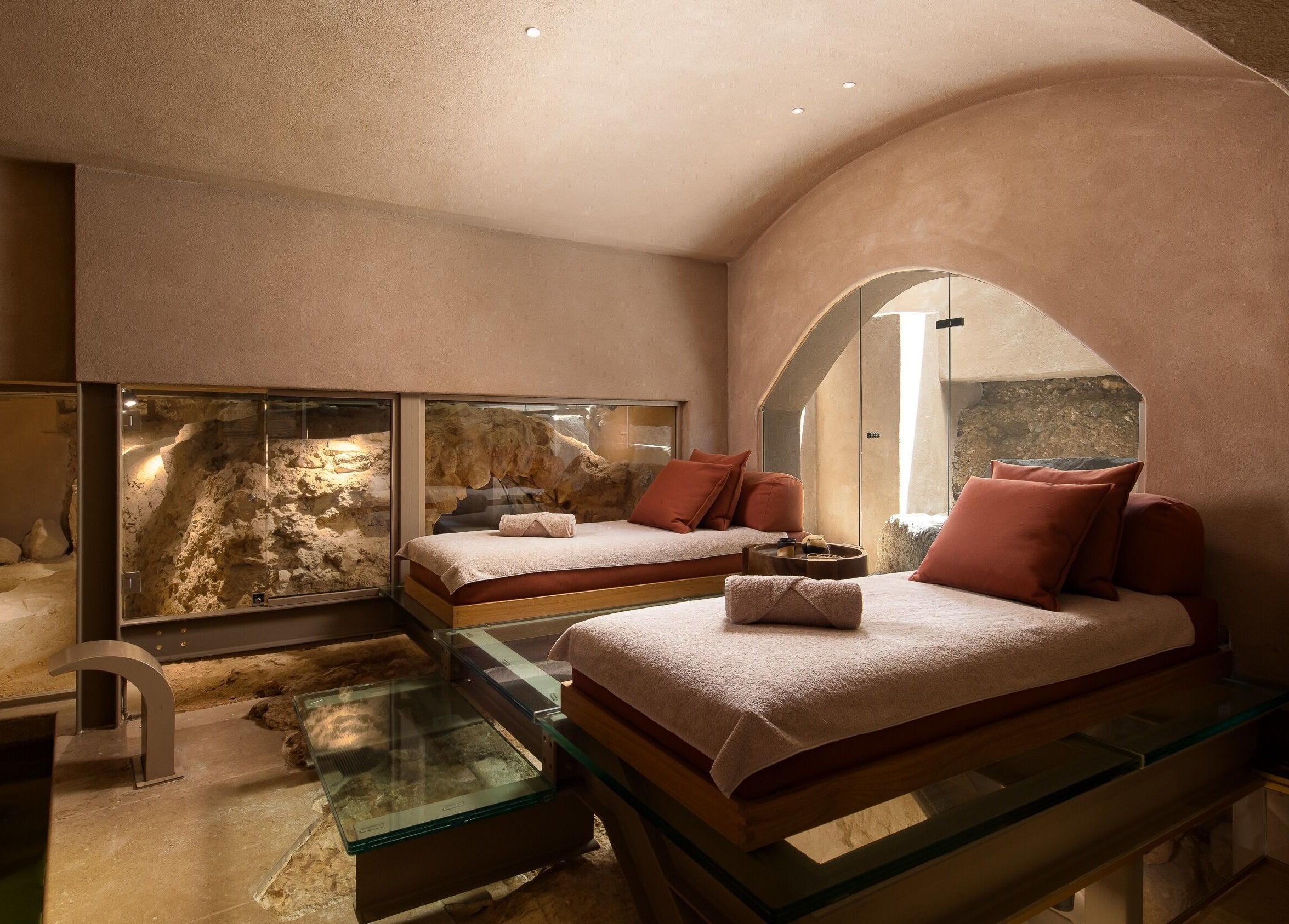 Luxurious therapy beds in a serene cave setting at Niche Spa 300 B.C., Athina, GR.