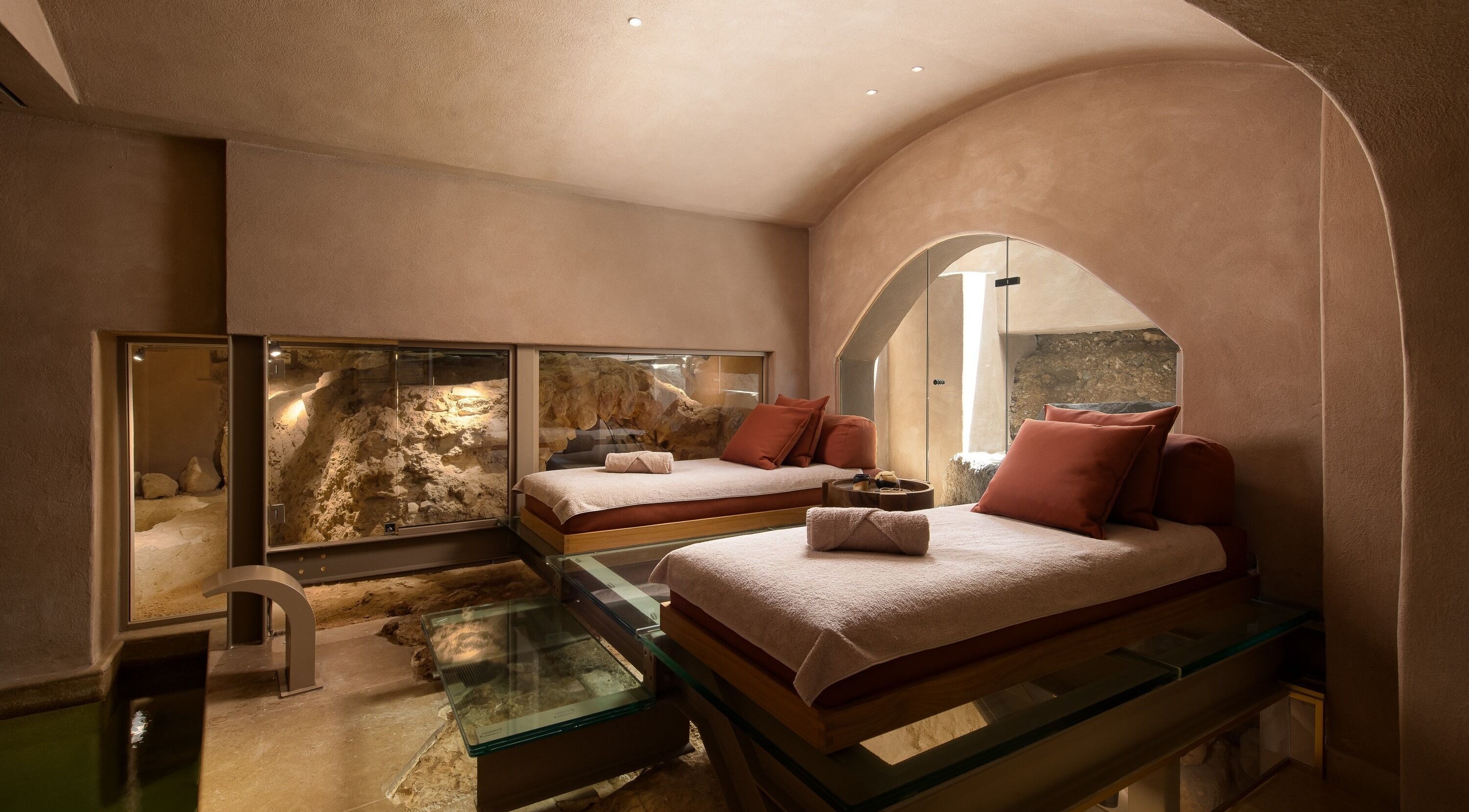 Luxurious therapy beds in a serene cave setting at Niche Spa 300 B.C., Athina, GR.
