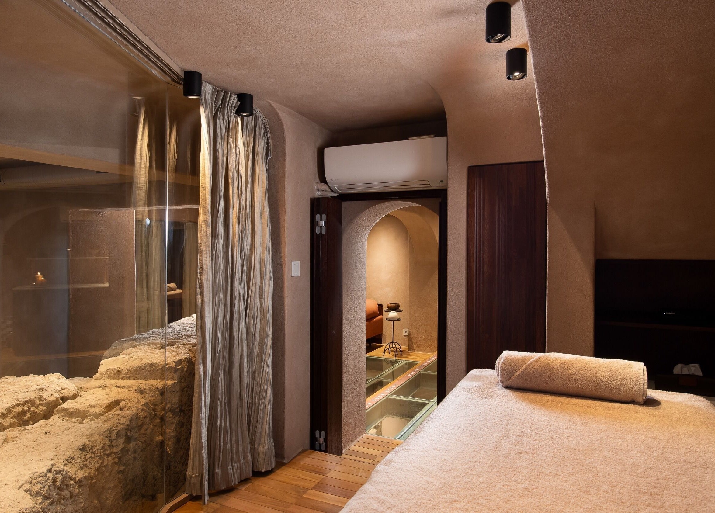 Tranquil massage room at Niche Spa 300 B.C., featuring natural rock and soft lighting in Athina, GR.