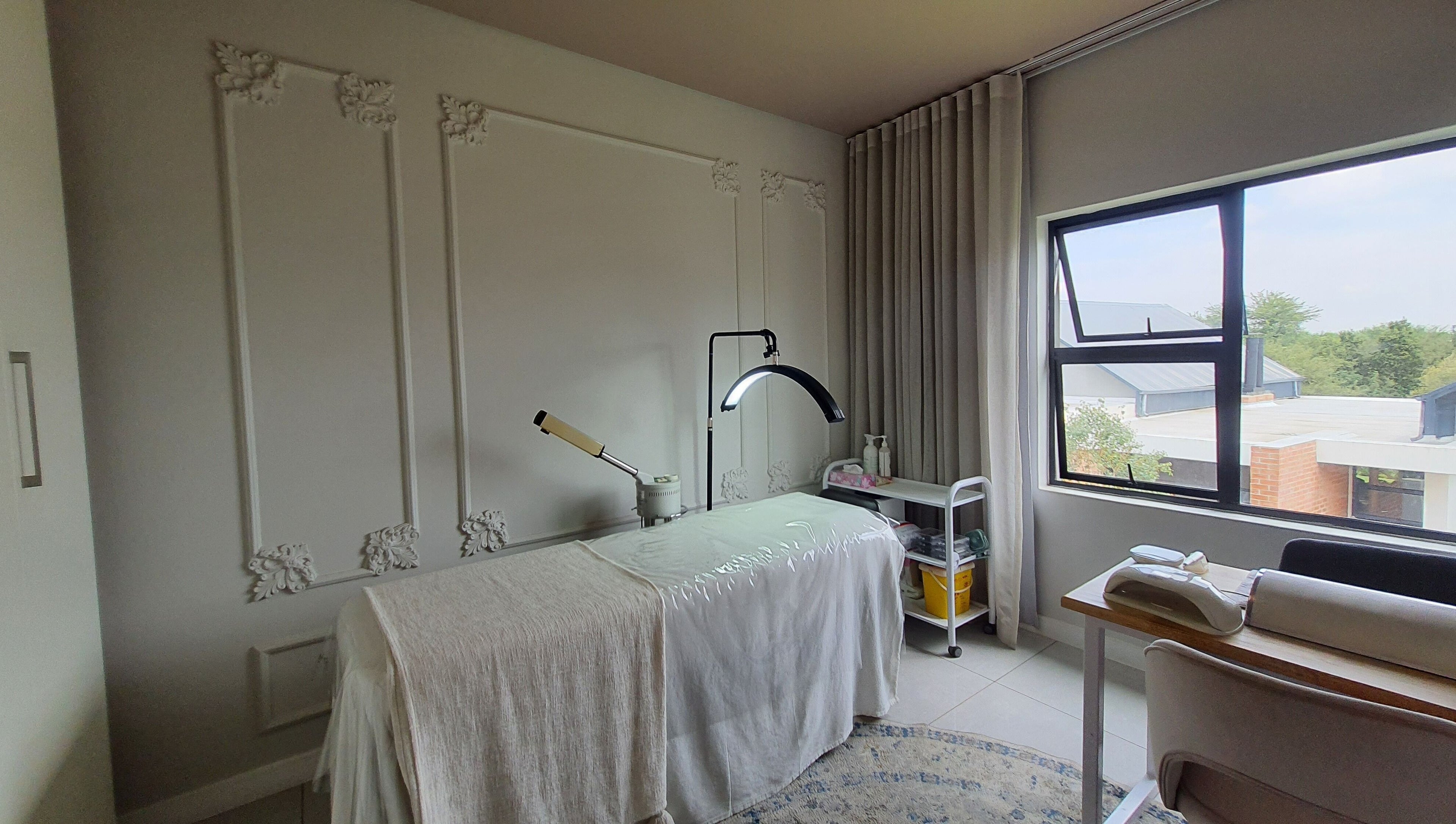 Serene treatment room at AesthetiDerm, Centurion, Gauteng, ZA with massage bed and natural light.
