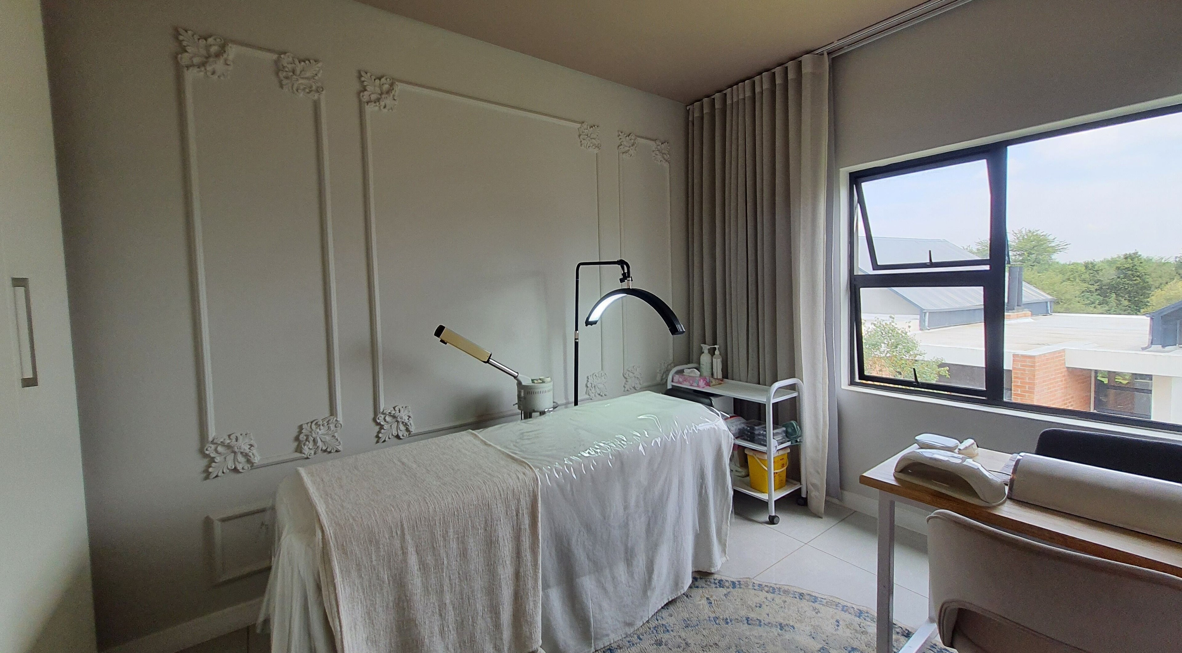 Serene treatment room at AesthetiDerm, Centurion, Gauteng, ZA with massage bed and natural light.