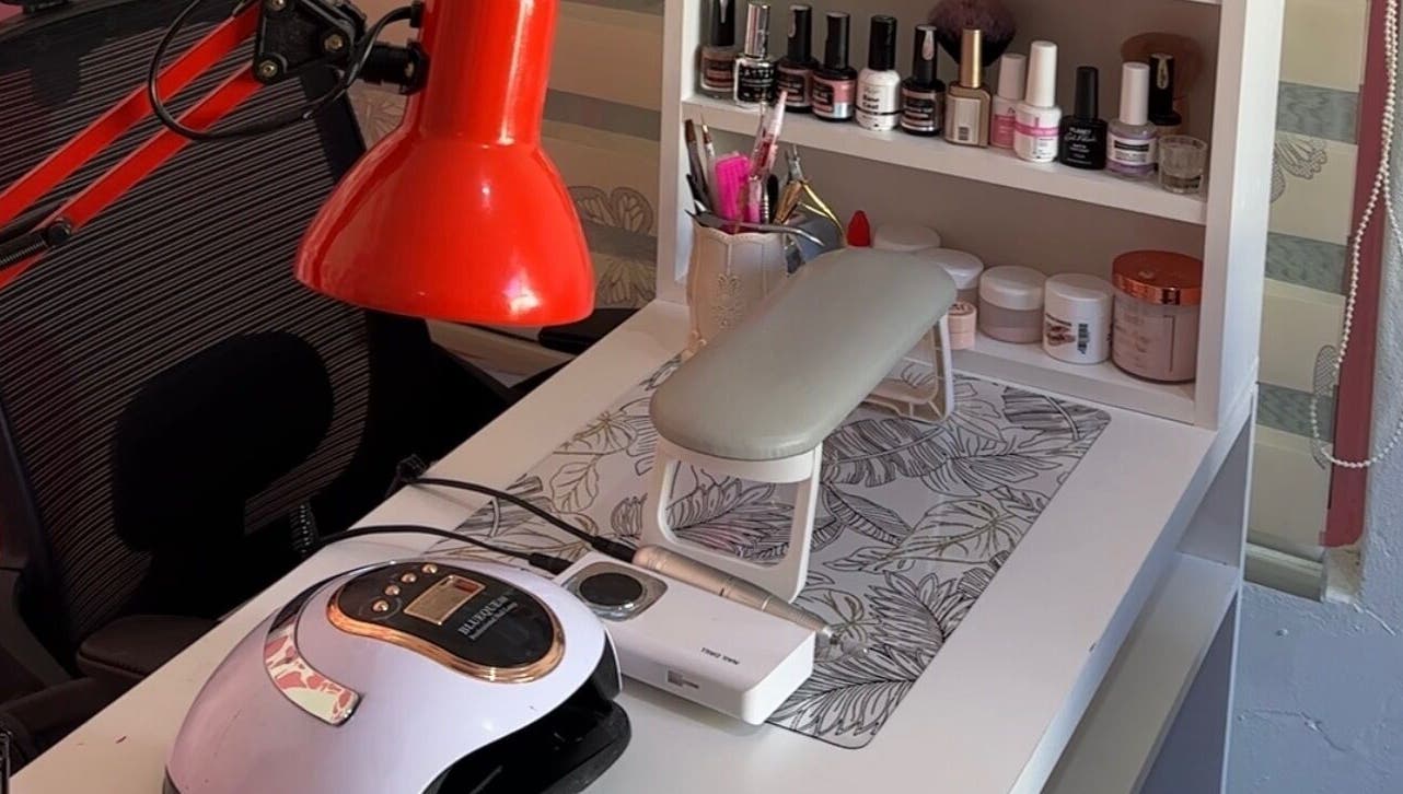 Nail care station at Eurie Nails, Randburg, Gauteng, ZA, featuring polish bottles and a red lamp.
