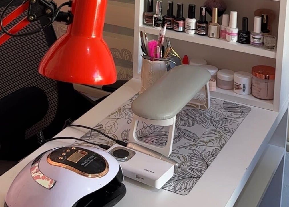 Nail care station at Eurie Nails, Randburg, Gauteng, ZA, featuring polish bottles and a red lamp.