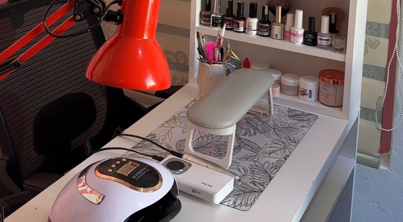 Nail care station at Eurie Nails, Randburg, Gauteng, ZA, featuring polish bottles and a red lamp.