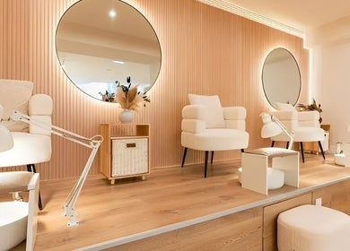 Chic nail salon interior at Voilà Nails and Beauty Oviedo, Oviedo, ES, featuring cozy chairs and modern mirrors.