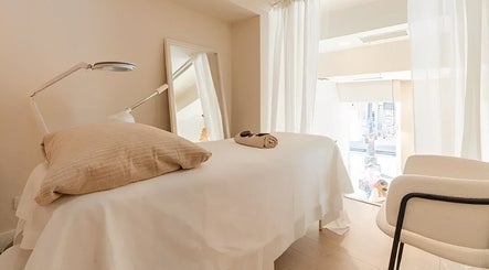 A tranquil massage room at Voilà Nails and Beauty Oviedo, featuring a cozy bed and soft lighting, Oviedo, ES.