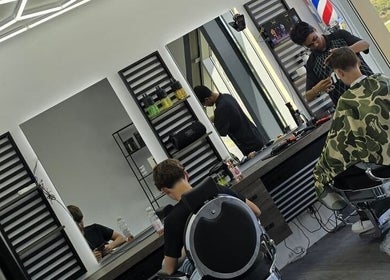 Interieur van Dimma The Barber in Zoetermeer, Zuid-Holland, NL met moderne kappersstoelen en spiegels.