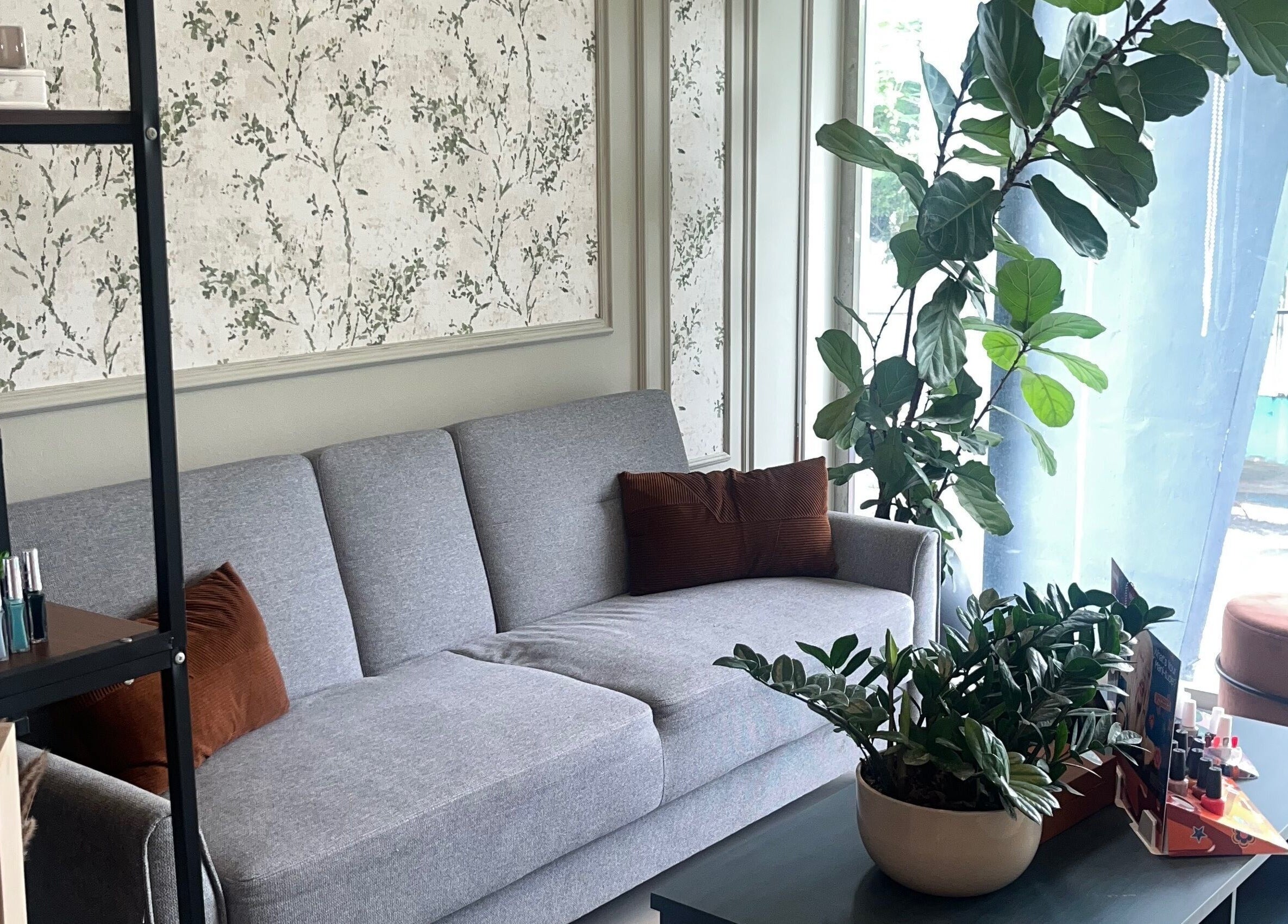 Elegante sala de espera en Lunaia Beauty Studio, La Vega, La Vega, DO, con sofá gris y decoración natural.