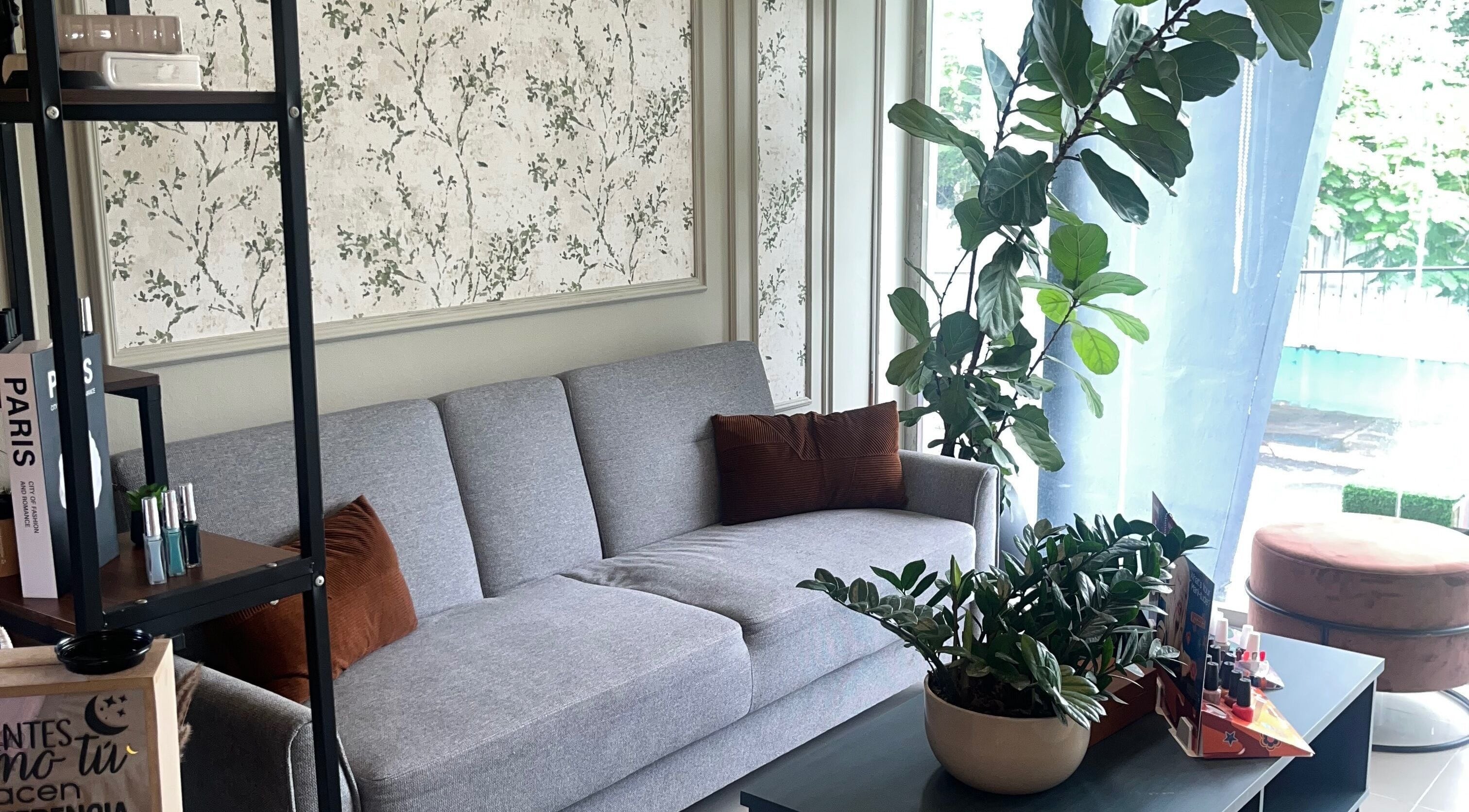 Elegante sala de espera en Lunaia Beauty Studio, La Vega, La Vega, DO, con sofá gris y decoración natural.