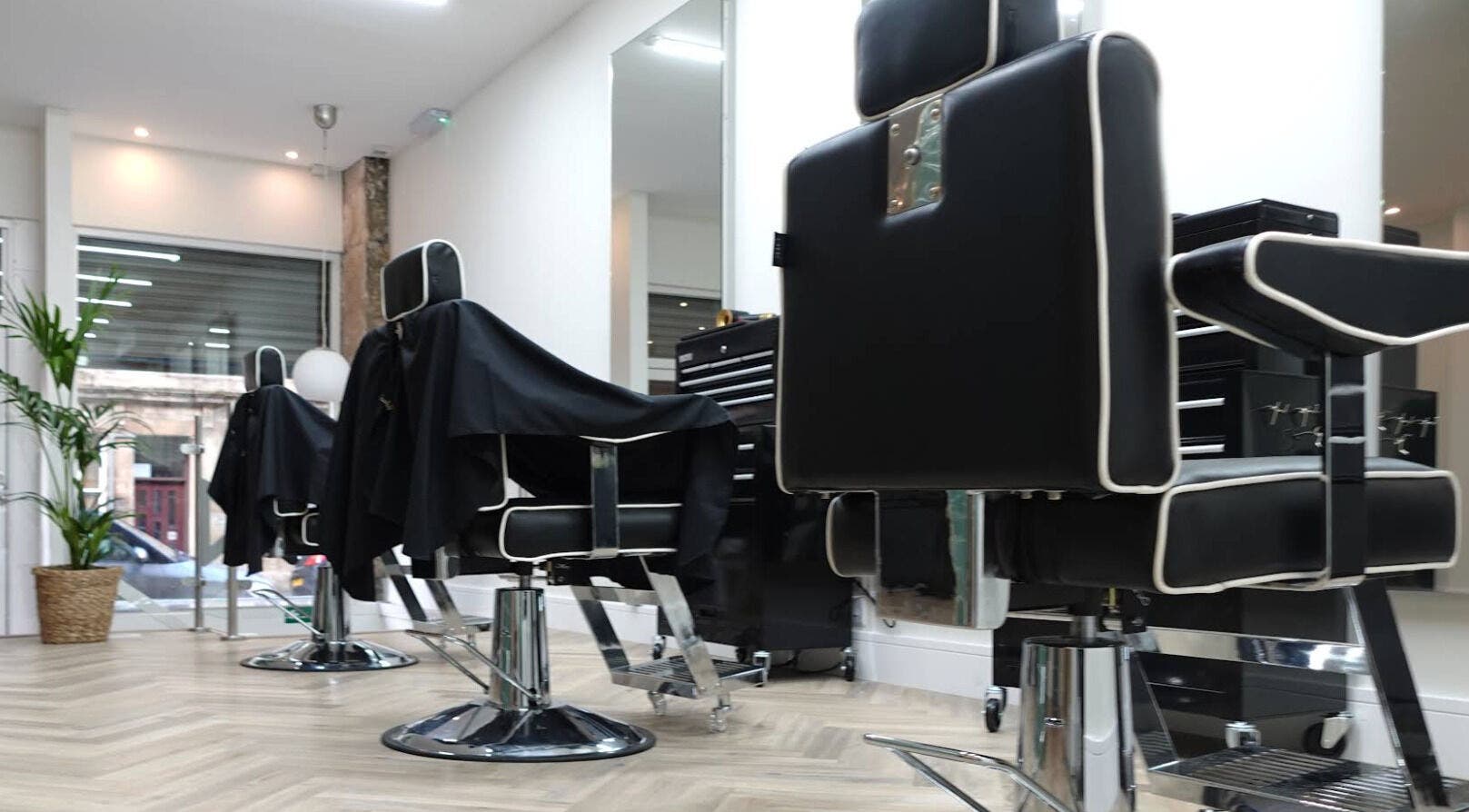 Modern barber chairs at INFINITE Gents Grooming in Glasgow, Scotland, GB with stylish interior.