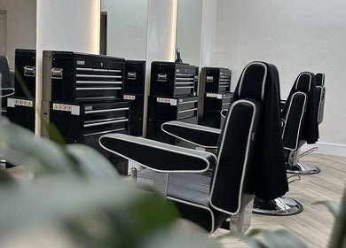 Stylish black grooming chairs at INFINITE Gents Grooming, Glasgow, Scotland, GB for an upscale experience.
