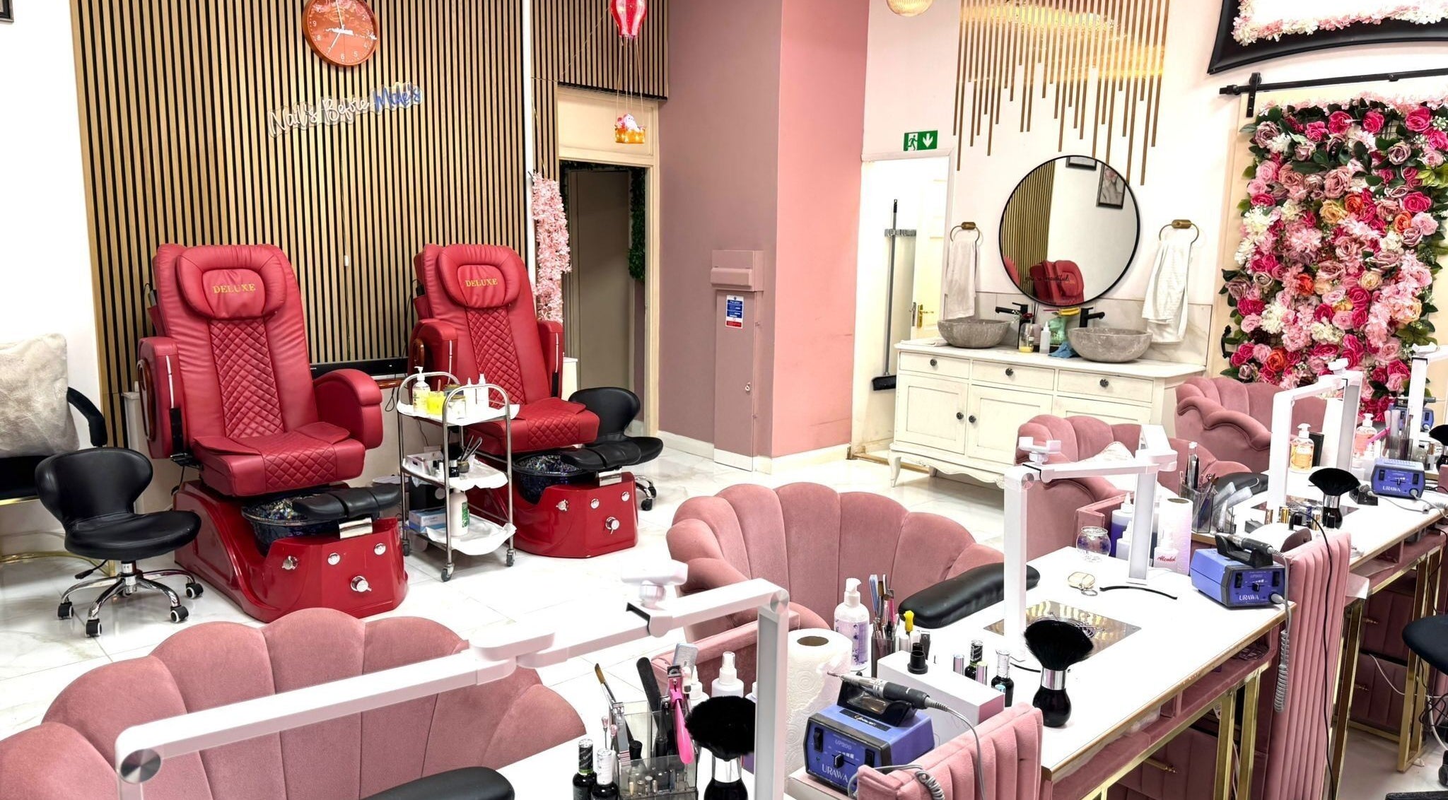 Elegant interior of Nikki D Nails Beauty Aesthetics in Chadwell St Mary, England with plush seating and floral decor.