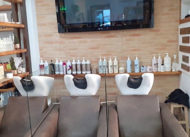Zona de lavado moderna en Pedro Riquelme, Región De Murcia, ES, con productos de belleza en estanterías.