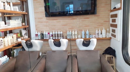 Zona de lavado moderna en Pedro Riquelme, Región De Murcia, ES, con productos de belleza en estanterías.