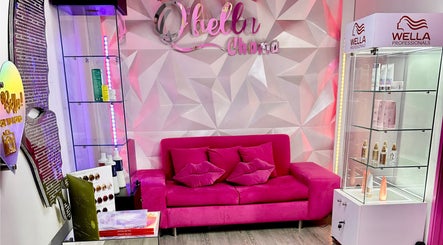 Elegante sala de espera en Qbellachama Santiago Centro, Región Metropolitana, CL, con sofá rosa vibrante.