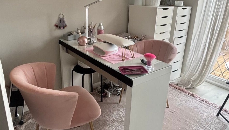 Stylish nail station at Aries Nails in Hitchin, England, GB, featuring plush pink chairs and organized workspace.