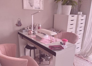 Elegantly designed nail station at Aries Nails, Hitchin, England, GB, featuring soft pink chairs and modern decor.