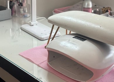 Modern nail station at Aries Nails, Hitchin, England, featuring a sleek UV lamp and tools for manicure services.
