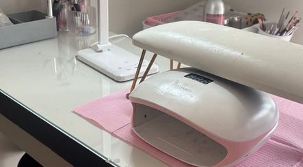 Cozy nail station setup at Aries Nails in Hitchin, England, GB featuring tools and a nail dryer.