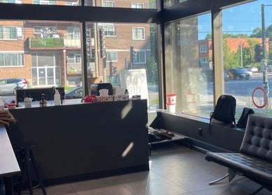 Cozy seating area at Tazi Beauty, Côte Saint-luc, Québec, CA with large sunlit windows and urban view.