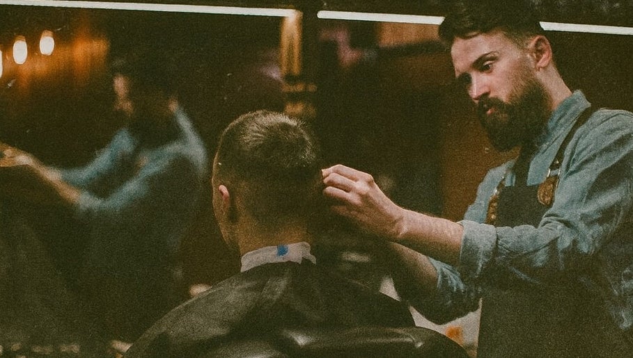 Barber at work in Barber Den, Valencia, Comunidad Valenciana, ES, crafting a modern haircut.