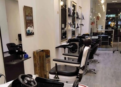 Modern interior of Barber Den in Valencia, Comunidad Valenciana, ES with sleek barber chairs.