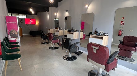 Interior moderno do Pixel Barbershop em Lisboa, Lisboa, PT, com cadeiras vermelhas e espelhos elegantes.