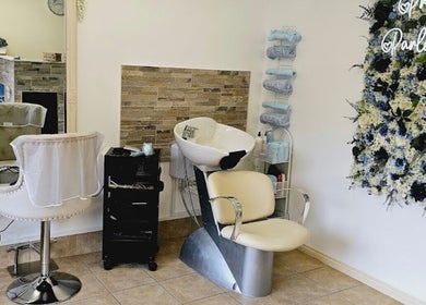 Chic salon interior with styling chair and floral wall at Pretty Parlour, Evesham, England, GB.