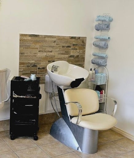 Chic salon interior with styling chair and floral wall at Pretty Parlour, Evesham, England, GB.