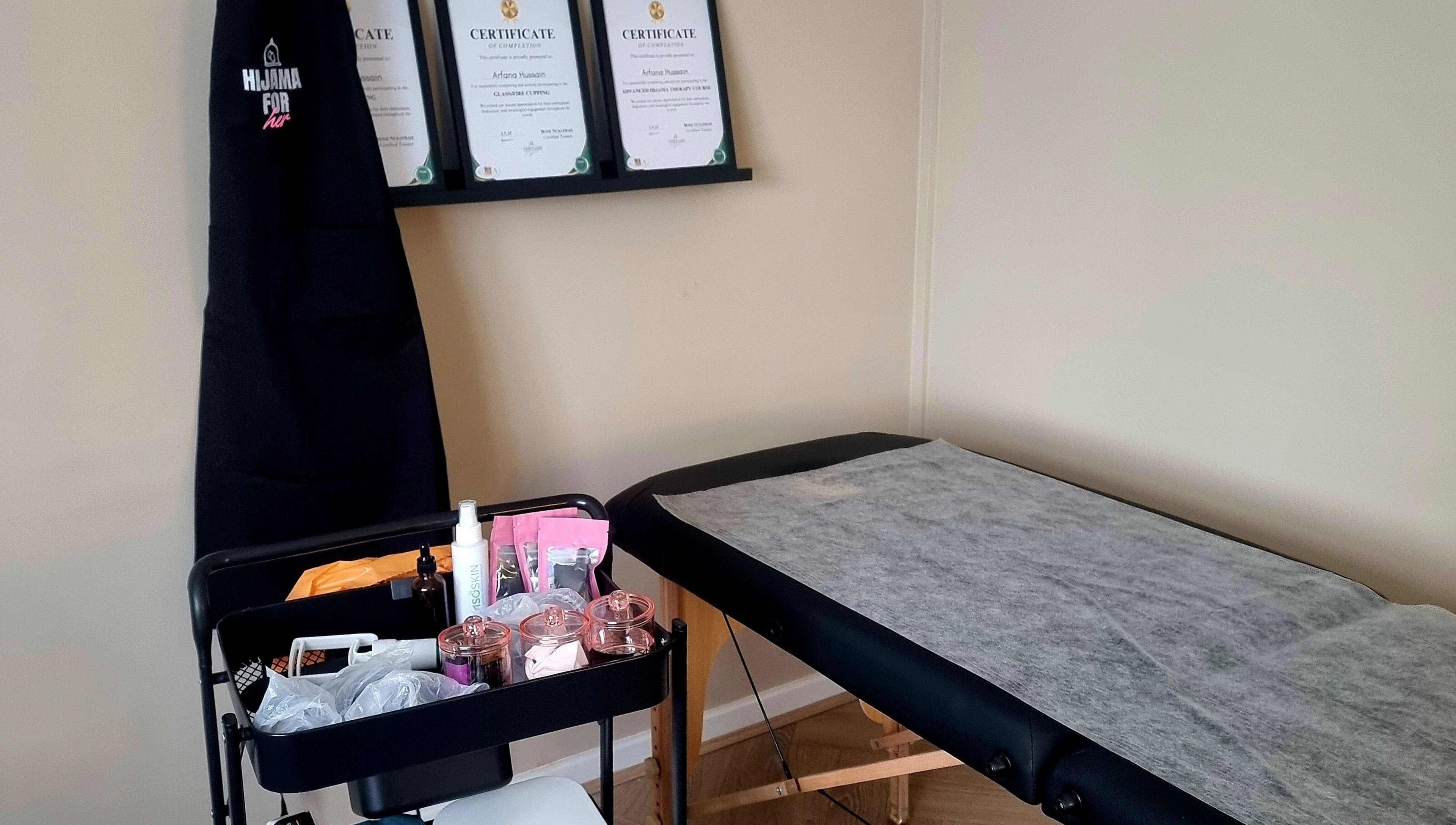 Hijama for Her treatment room in Tipton, England, GB, featuring a massage table and wellness certificates.