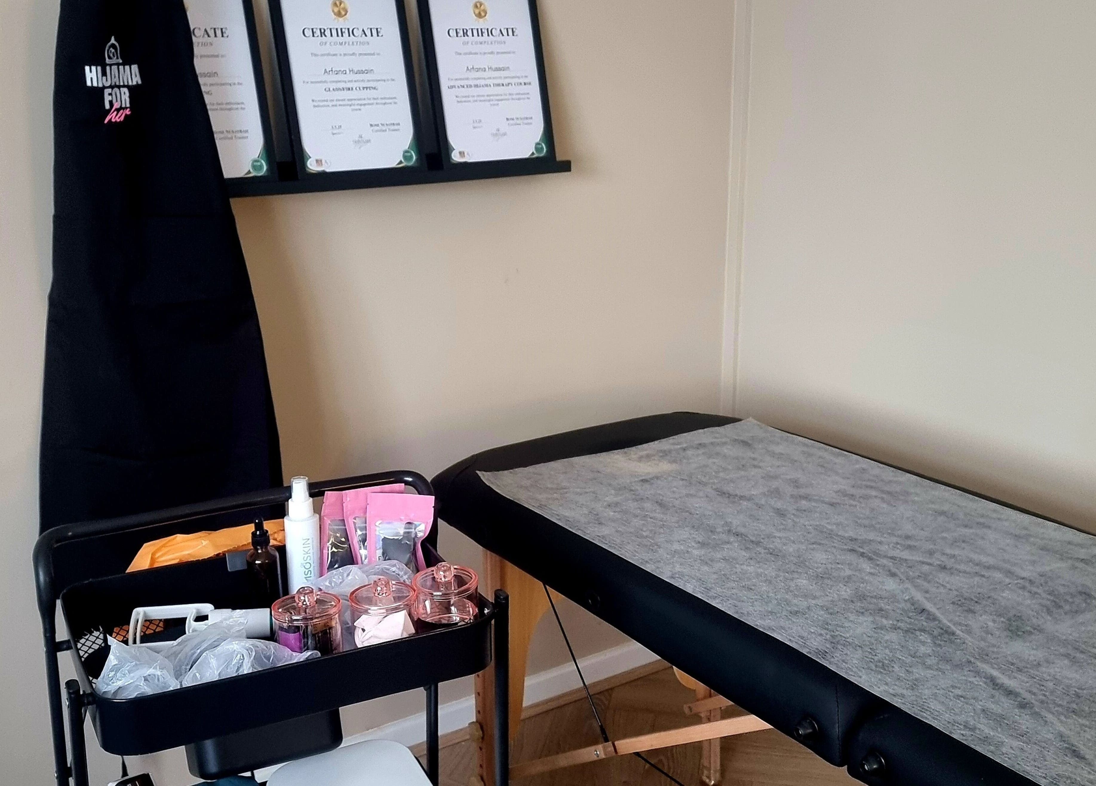Hijama for Her treatment room in Tipton, England, GB, featuring a massage table and wellness certificates.