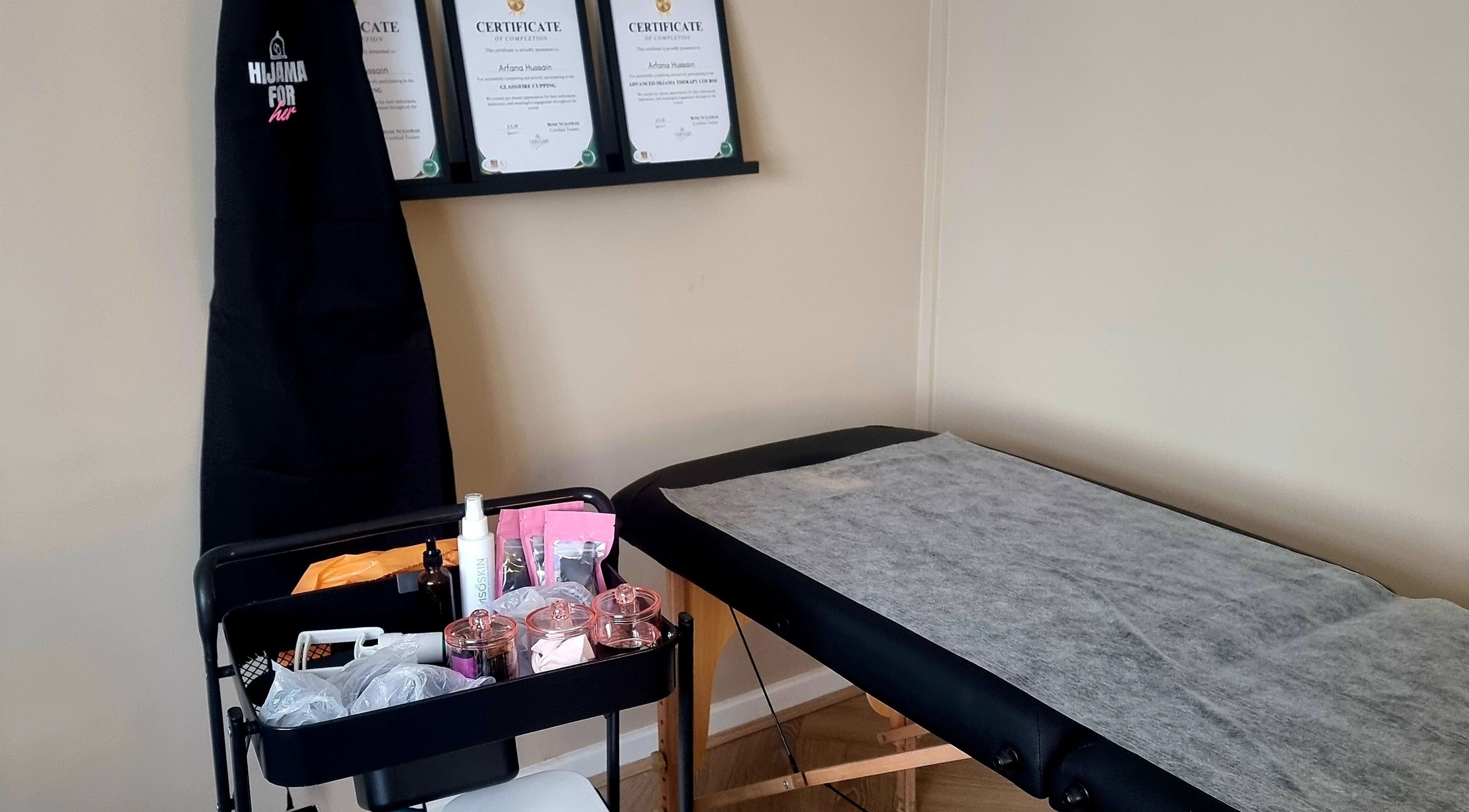 Hijama for Her treatment room in Tipton, England, GB, featuring a massage table and wellness certificates.