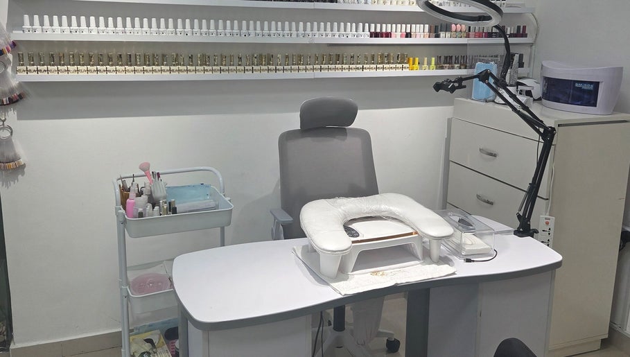 Nail station at Aljamal Almithali Beauty Salon in Ajman, AE, showcasing tools and vibrant polish selection.