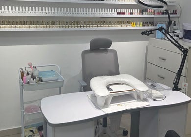 Nail station at Aljamal Almithali Beauty Salon in Ajman, AE, showcasing tools and vibrant polish selection.