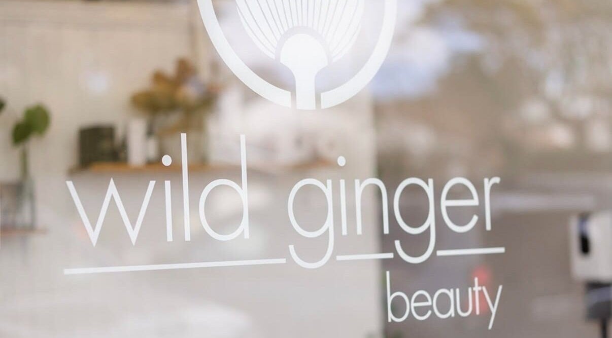 Wild Ginger Beauty logo on a glass window in Curl Curl, New South Wales, AU, reflecting tranquil interiors.