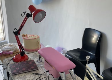 Nail station setup at Nailed By Ndasi, Gqeberha, Eastern Cape, ZA with a red lamp and pink armrest.