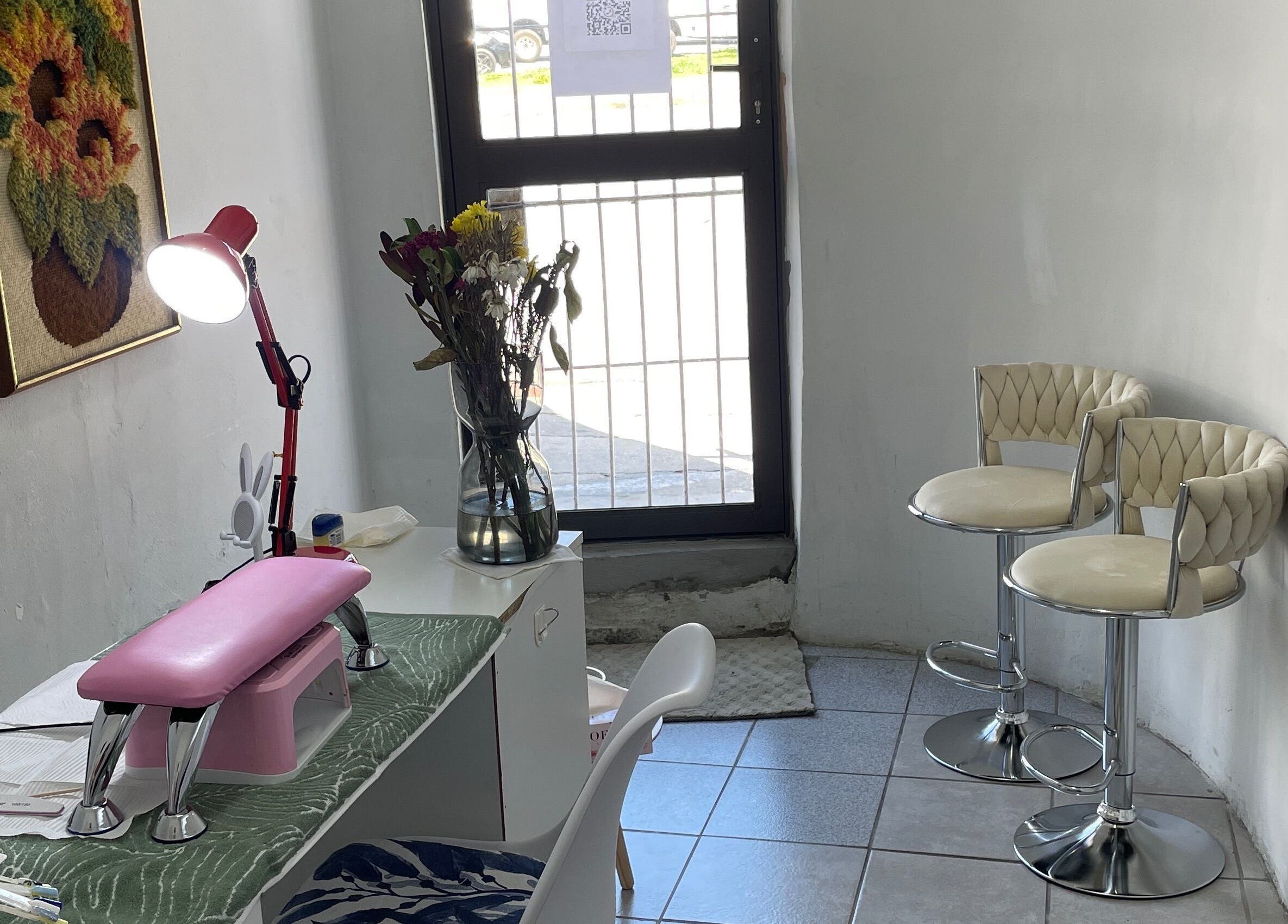 Nailed By Ndasi in Gqeberha offers a cozy nail space with modern seating and floral decor.
