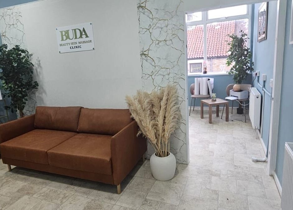 Inviting lounge area at Buda Beauty, Shildon, England, GB with cozy sofa and plants.